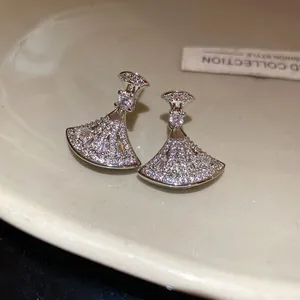 Detailed macro view of elegant silver fan-shaped earrings with sparkling zircon stones