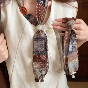 Close-up of ethnic patterned fabric necklace with pearl and amber bead details