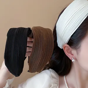 Detailed view of pleated wide fabric headbands in black, brown, and white colors