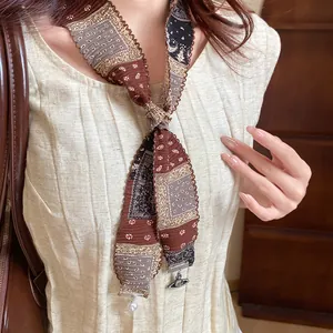 Close-up of ethnic style fabric necklace featuring pearl and vintage orb pendant detail