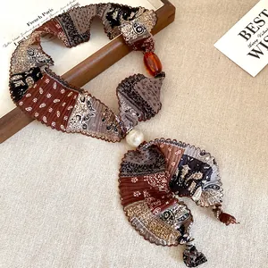 Vintage ethnic style fabric necklace featuring pearl and amber resin bead details