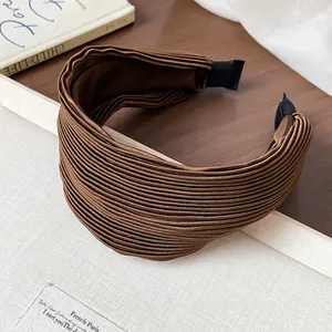Macro detail of high top brown pleated fabric headband with elegant wide surface design