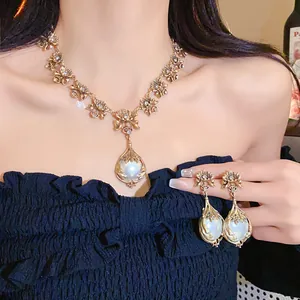 Detailansicht eines Vintage-Schmucksets mit Perlenblumenkette und Ohrringen am Modell.