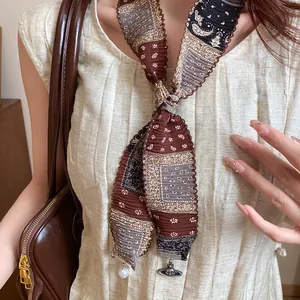 Close-up of vintage ethnic fabric necklace featuring a pearl and Saturn orb pendant