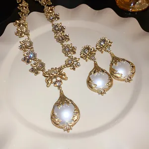 Nahaufnahme von Vintage-Gold-Blumen-Halskette und Ohrringen mit leuchtenden Perlen