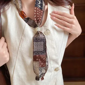 Close-up of vintage paisley fabric necklace featuring amber resin and pearl beads