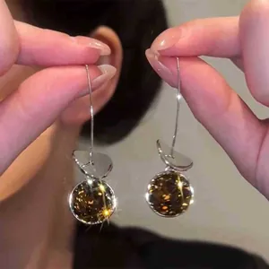 Detail shot of geometric drop earrings with sparkling brown faceted crystal spheres