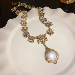 Nahaufnahme der Vintage-Halskette mit Blumenmuster, Perlenanhänger und glänzenden Strass