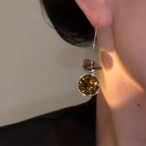 Close-up view of vintage geometric ear hooks featuring sparkling faceted brown crystals