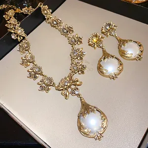 Detailansicht eines Vintage-Blumenschmucksets mit Perlen und Strass auf Golddekor