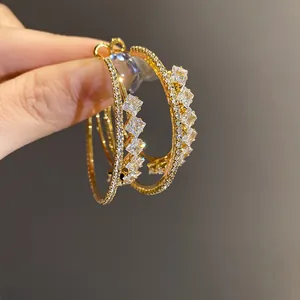 Close-up of 18k gold-plated double-layer hoop earrings with square zircon details.