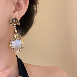 Detaillierte Nahaufnahme goldener Vintage-Ohrring mit Perlenanhänger an einem Modell