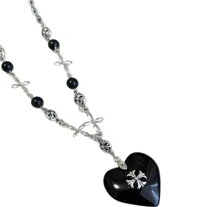 Vintage gothic necklace featuring a large black heart pendant and silver cross design links