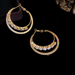 Detailed macro shot of 18k gold-plated double-layered hoop earrings with sparkling zircons.