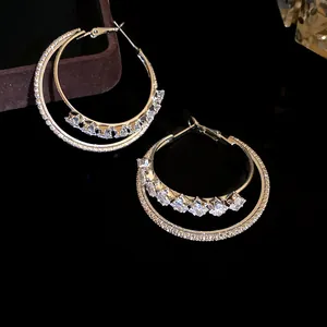 Macro view of elegant double-layered hoop earrings featuring brilliant square zircons.