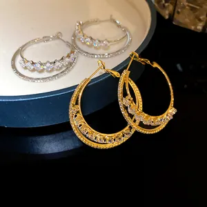 Macro detail of 18k gold plated double layer hoop earrings featuring sparkling cubic zircons