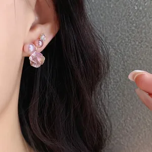 Elegant silver needle stud earrings featuring pink pearls and a crystal-set flower design