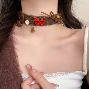 Close-up of brown knitted butterfly choker with button charms and leather bow detail