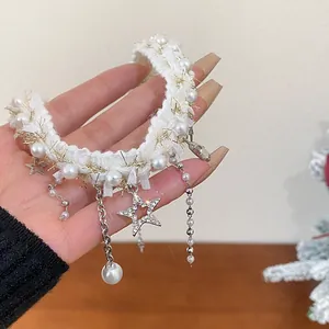 Detailed view of white furry choker necklace with rhinestone star and pearl dangles.