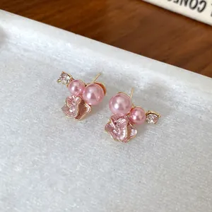 Macro detail of elegant pink pearl earrings with flower petal and clear rhinestone