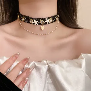 Close-up of a black woven choker with rhinestones, starfish, and a gold heart pendant