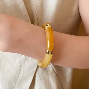 Close-up of a vintage amber acrylic segment bracelet with elegant gold-tone accents