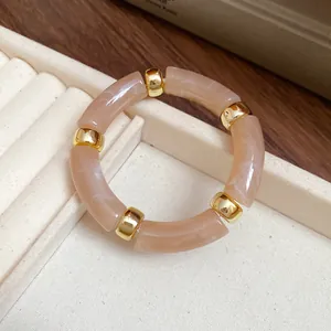 Detailed close-up of a vintage marbled acrylic segment bracelet with gold bead accents