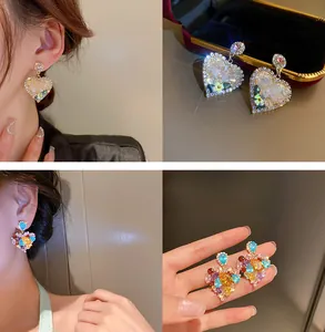 Dettaglio di orecchini a cuore bohémien con cristalli colorati e strass scintillanti