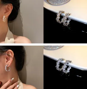 Primo piano e vista indossata di orecchini a cerchio con cristalli oro e argento