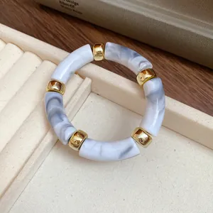 Close-up of acrylic marbled bracelet segments with gold spacers on jewelry tray