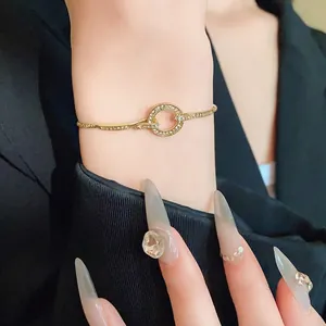 Elegant gold-tone adjustable bracelet with a sparkling rhinestone circle charm