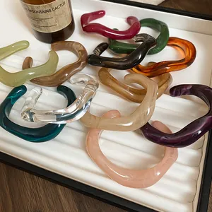Gros plan détaillé de divers bracelets en résine acrylique ondulés colorés sur un plateau