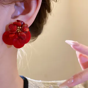 Dettaglio ravvicinato di orecchini a fiore in conchiglia rossa in stile vintage
