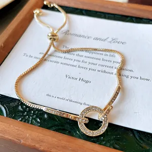 Detailed close-up of a gold-toned rhinestone adjustable bracelet on a decorative card