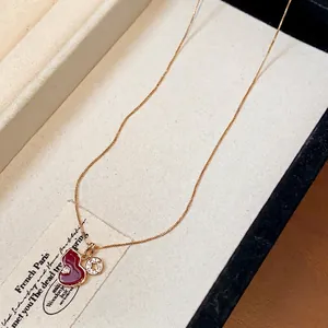 Elegant gold chain necklace featuring a red enamel gourd pendant with zircon charm accents