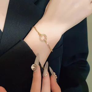 Detail of elegant gold-tone adjustable bracelet with sparkling rhinestone circle.