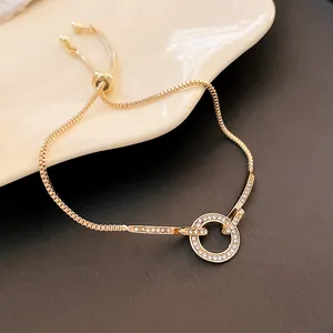 Detailed view of gold adjustable bracelet with rhinestone-encrusted circular ring