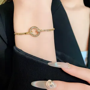Macro view of a gold-plated bracelet featuring a rhinestone-encrusted circle on wrist