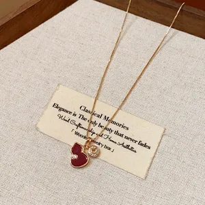 Detail of gold enamel gourd pendant necklace with sparkling zircon charm on card