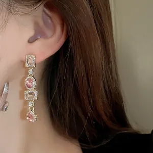 Primo piano di orecchini pendenti in stile retrò con cristalli rosa e ago in argento puro