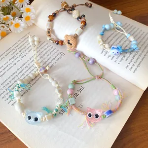 Detailed macro shot of cute handmade ceramic cat and dog beaded bracelets on a book