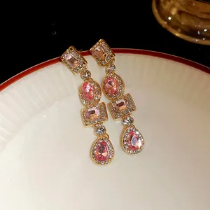 Primo piano di orecchini vintage geometrici con cristalli rosa e finitura dorata