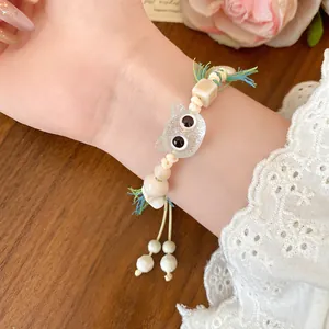 Detailed view of a cute ceramic beaded cat bracelet with tassel and googly eyes