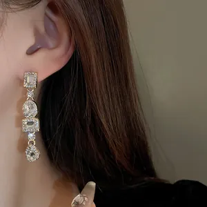 Orecchini pendenti geometrici dorati con cristalli scintillanti per un look vintage elegante.