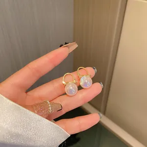 Detailed close-up of elegant mermaid pearl hoop earrings with a radiant golden finish