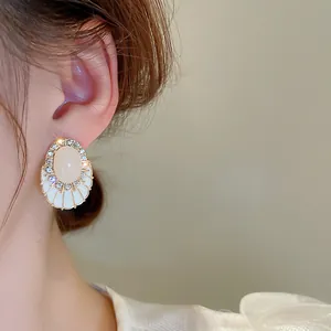 Gros plan d'une boucle d'oreille élégante en zircone avec émail et pierre rose