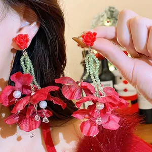 Exaggerated red fabric flower earrings with green beads and white pearls for New Year