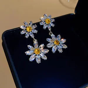 Vue macro détaillée de boucles d'oreilles marguerites avec zircone jaune cubique