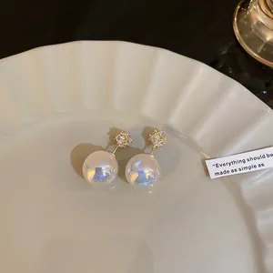 Detailed close-up of vintage mermaid pearl stud earrings with sparkling crystal accents.