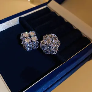 Gros plan détaillé de boucles d'oreilles géométriques en zircons dans un écrin en velours